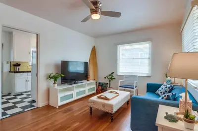 a living room with a blue couch and a tv at California Cottage near SDSU in San Diego