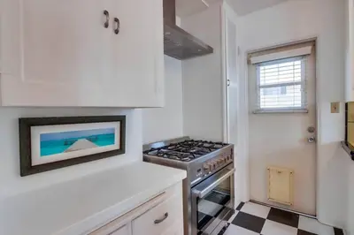 a kitchen with a stove top oven next to a window at California Cottage near SDSU in San Diego