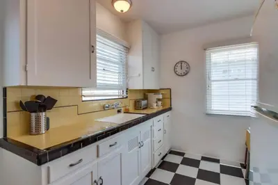 a kitchen with a sink and a clock on the wall at California Cottage near SDSU in San Diego