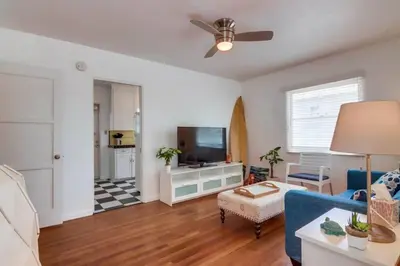a living room with a blue couch and a flat screen tv at California Cottage near SDSU in San Diego