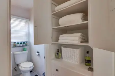 a bathroom with a white toilet and towels at California Cottage near SDSU in San Diego