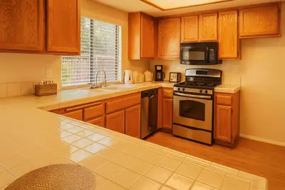 a kitchen with wooden cabinets and a stove top oven at Western Horizon Home in Hemet