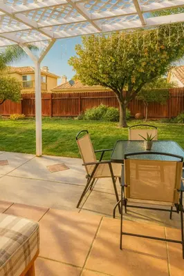 a patio with a table and chairs under a pergola at Peach Blossom Country House in Hemet