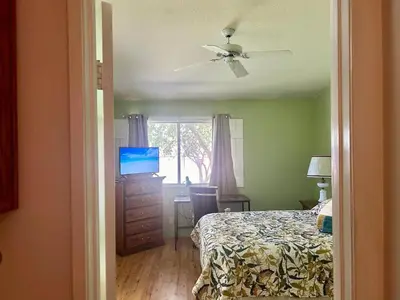 a bedroom with a bed and a desk with a television at Peach Blossom Country House in Hemet