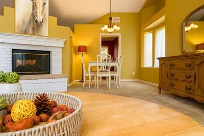 a living room with yellow walls and a fireplace at Peach Blossom Country House in Hemet