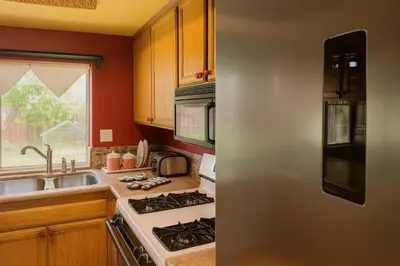 a kitchen with a stove top oven next to a sink at Peach Blossom Country House in Hemet