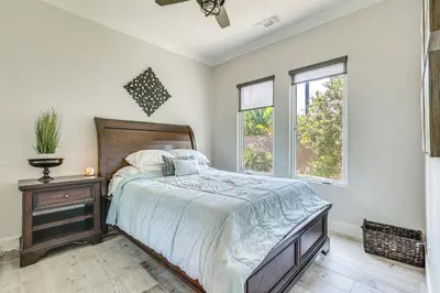 a bedroom with a bed and a dresser and windows at LA COSTA Valley Newly Remodeled Gem in Carlsbad