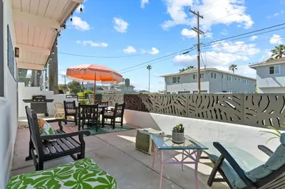 a patio with chairs and tables and an umbrella at Amazing Place by the Sea - O'side Palms in Oceanside