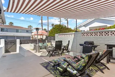 a patio with chairs and tables and a grill at Beach Meets Fabulous at Oside Palms in Oceanside