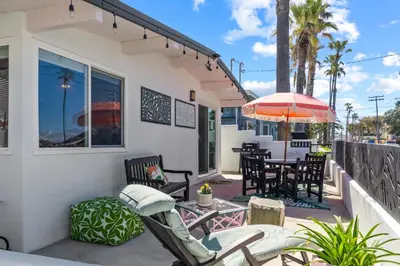 a patio with chairs and a table and an umbrella at Beach Meets Fabulous at Oside Palms in Oceanside
