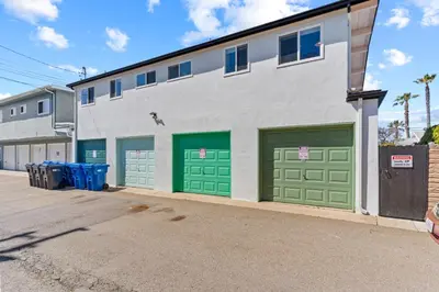 a building with green garage doors on a street at Beach Meets Fabulous at Oside Palms in Oceanside