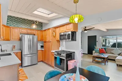 a kitchen and living room with a stainless steel refrigerator at Beach Meets Fabulous at Oside Palms in Oceanside