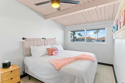 a bedroom with a bed with a pink blanket on it at California Dreamin at O'side Palms in Oceanside
