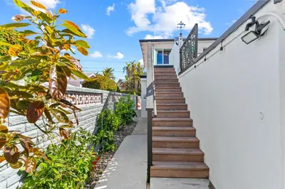 a staircase leading up to a house with a white wall at California Dreamin at O'side Palms in Oceanside