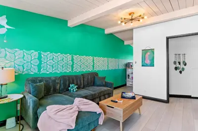 a living room with a couch and a green wall at California Dreamin at O'side Palms in Oceanside