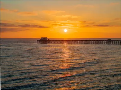 a pier in the ocean at sunset at Day in Paradise at Oside Palms in Oceanside