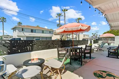 a patio with chairs and tables and an umbrella at Day in Paradise at Oside Palms in Oceanside