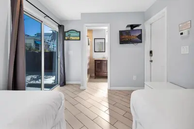 a bedroom with two beds and a view of a bathroom at Stunning Beach Haven! Steps to the Beach & Pet Friendly! in San Diego