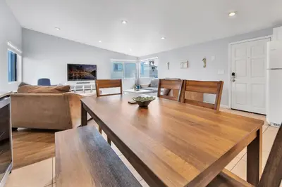 a living room with a table and a couch at Stunning Beach Haven! Steps to the Beach & Pet Friendly! in San Diego