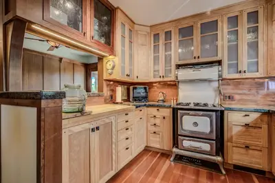 a kitchen with wooden cabinets and a stove at The Craftsman Coastal Cottage in Leucadia in Encinitas