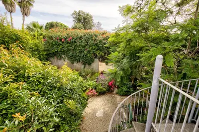 a garden with a gate and flowers at The Craftsman Coastal Cottage in Leucadia in Encinitas