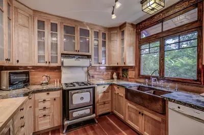 a kitchen with wooden cabinets and a sink at The Craftsman Coastal Cottage in Leucadia in Encinitas
