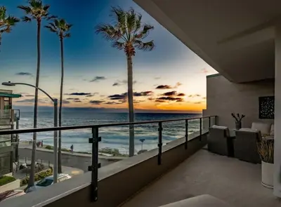 a balcony with a view of the ocean and palm trees at Beachside Paradise in Windansea in San Diego