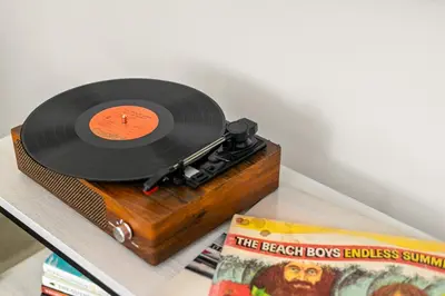 a vinyl record on a table next to a book at Modern and Cozy in PB with Patio and Firepit in San Diego