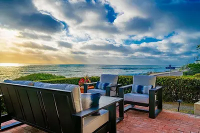 a patio with chairs and a table and the ocean at Oceanfront Townhome with Breathtaking Views in San Diego