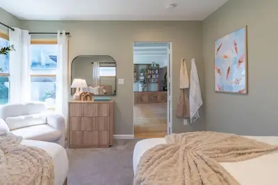 a bedroom with a bed and a chair and a mirror at Perched Ocean Paradise in San Diego