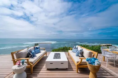 a deck with couches and a table and the ocean at Perched Ocean Paradise in San Diego