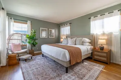 a bedroom with a large bed and a chair at Perched Ocean Paradise in San Diego