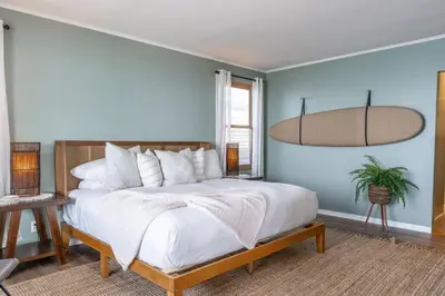 a bedroom with a large bed and a blue wall at Perched Ocean Paradise in San Diego