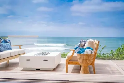 a living room with a table and a chair and the ocean at Perched Ocean Paradise in San Diego