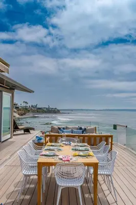 a wooden deck with a table and chairs and the ocean at Perched Ocean Paradise in San Diego