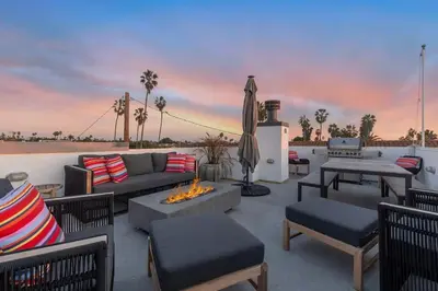 a patio with a couch and chairs and a fire pit at Ocean View Gem with Rooftop Deck and Hot Tub in San Diego