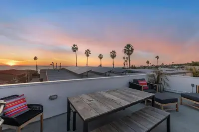 a rooftop patio with a wooden table and chairs at Ocean View Gem with Rooftop Deck and Hot Tub in San Diego