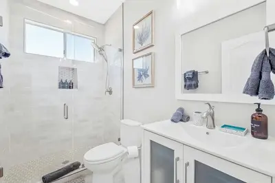 a white bathroom with a toilet and a shower at Ocean View Gem with Rooftop Deck and Hot Tub in San Diego
