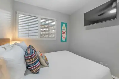 a white bedroom with a bed and a window at Ocean View Gem with Rooftop Deck and Hot Tub in San Diego