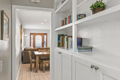 a hallway with bookshelves and a dining room at Coastal Chic at Windansea in San Diego