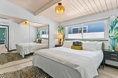 a bedroom with a large white bed and a window at O'side Palms Multi Units in Oceanside