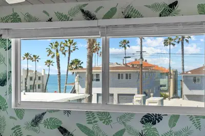 a window with a view of the ocean and palm trees at O'side Palms Multi Units in Oceanside