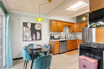 a kitchen with a table and chairs and a refrigerator at O'side Palms Multi Units in Oceanside