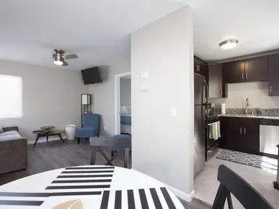 a living room with a kitchen and a living room with a table at Ocean Front, Steps Mission Beach, Bay, Remodeled, Mission Beach Jamaica FLAT in San Diego
