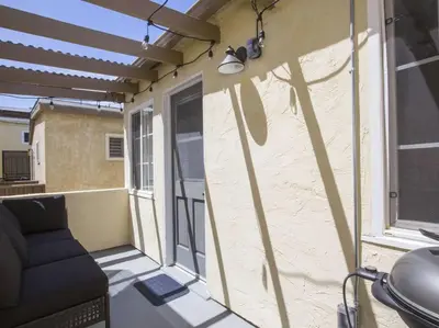 a screened in porch with a couch and a window at Ocean Front, Steps Mission Beach, Bay, Remodeled, Mission Beach Jamaica FLAT in San Diego
