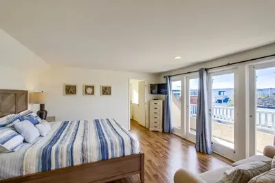 a bedroom with a bed and a balcony at Massive Beach Home with Ocean View & Amazing Rooftop in San Diego