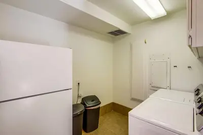 a kitchen with a refrigerator and a trash can at Massive Beach Home with Ocean View & Amazing Rooftop in San Diego