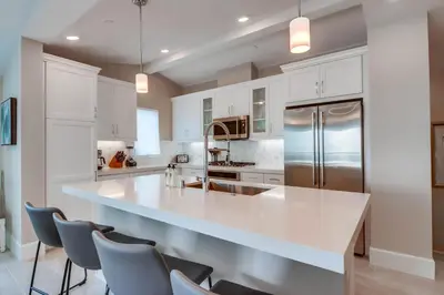 a kitchen with white cabinets and a large white counter top at Newly Built Bayside Dream, Fire Pit & Bay Views in San Diego