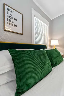a bed with a green pillow and a picture on the wall at Bankers Hill Hideaway with AC Views and Parking in San Diego