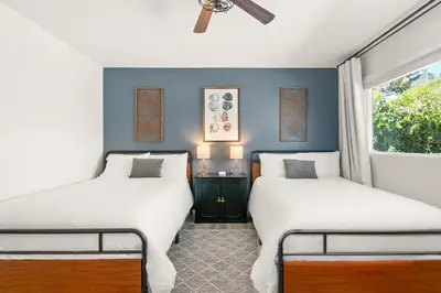 two beds in a room with blue walls and a window at Oceanside Oasis - King Bed, Pet Friendly, Fire Pit in Oceanside